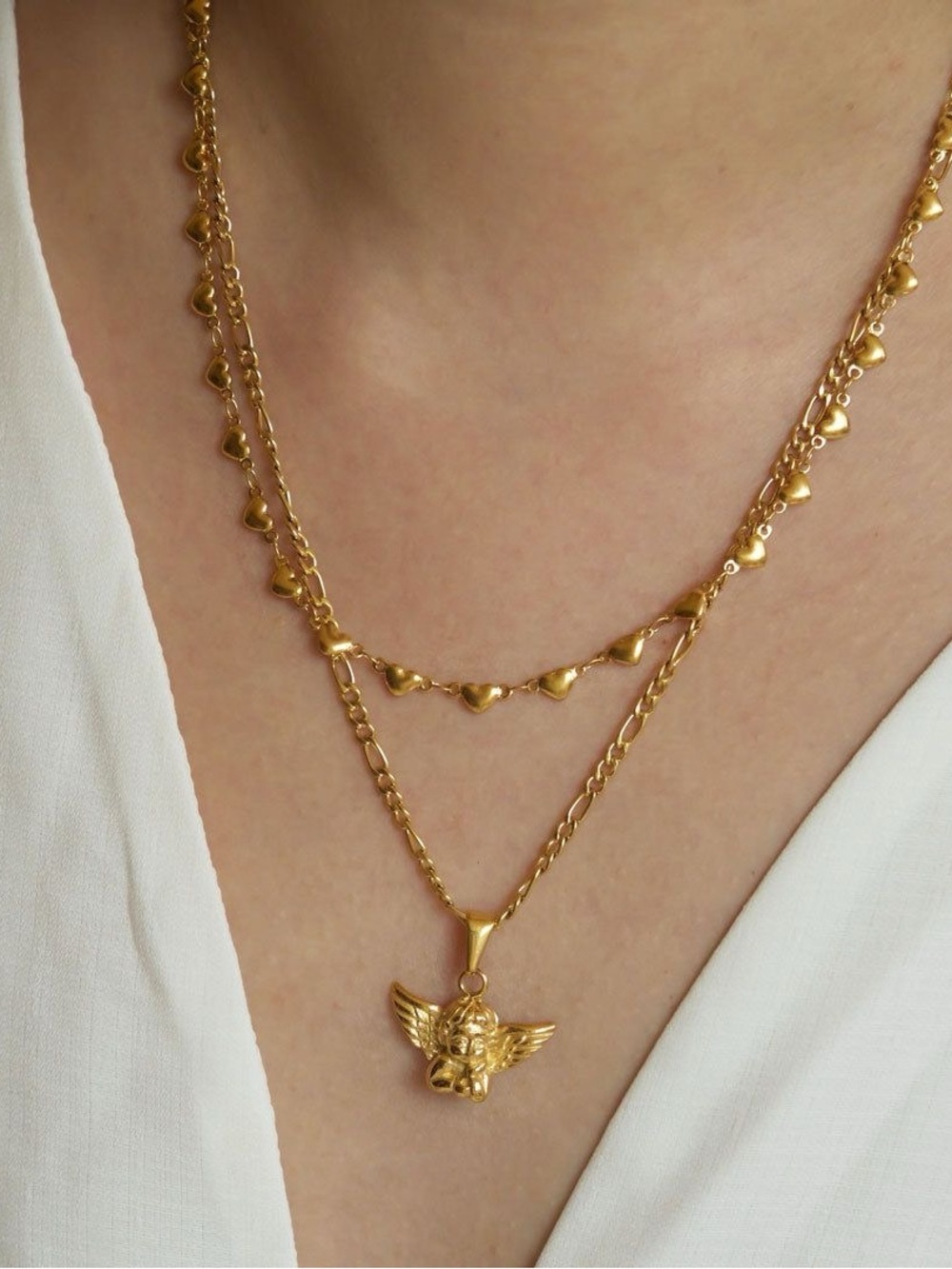 This dainty gold-tone chain necklace features a charming textured cherub pendant